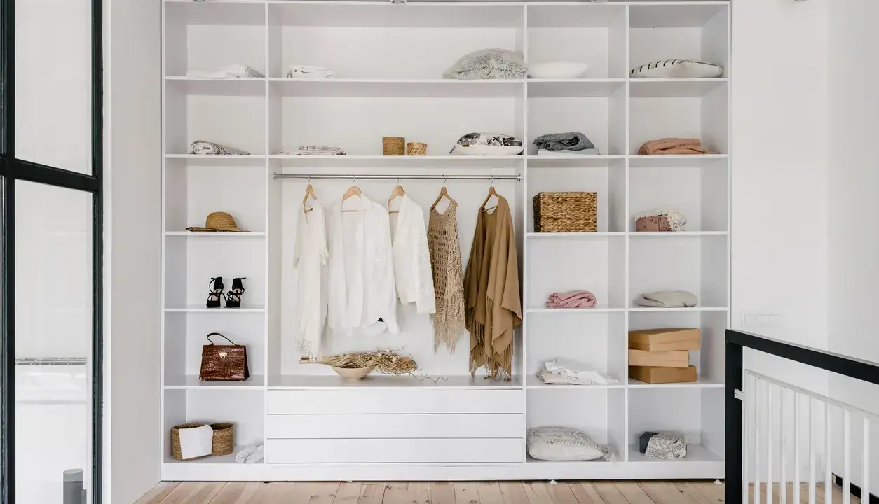 Ecco un esempio di come organizzare un armadio a muro: ripiani ordinati con abiti appesi, borse, cappelli e accessori.