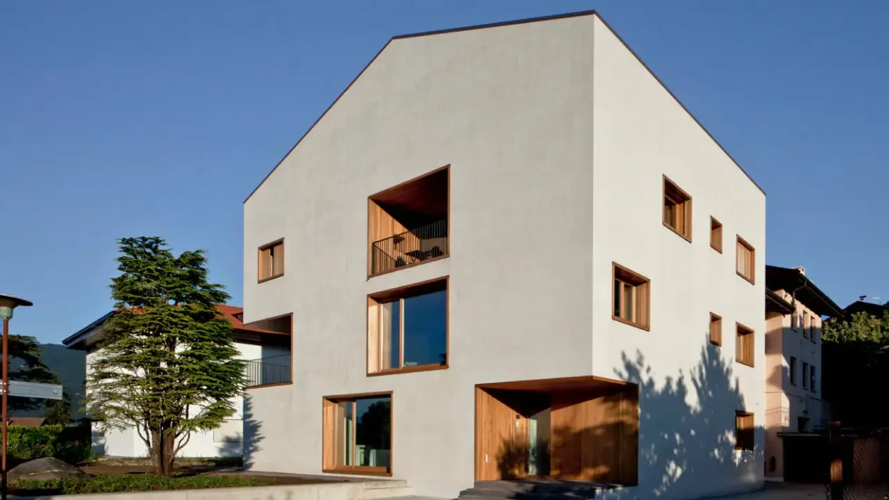 Casa moderna con ampie vetrate e balconi, un esempio di case in classe a vantaggi e svantaggi.