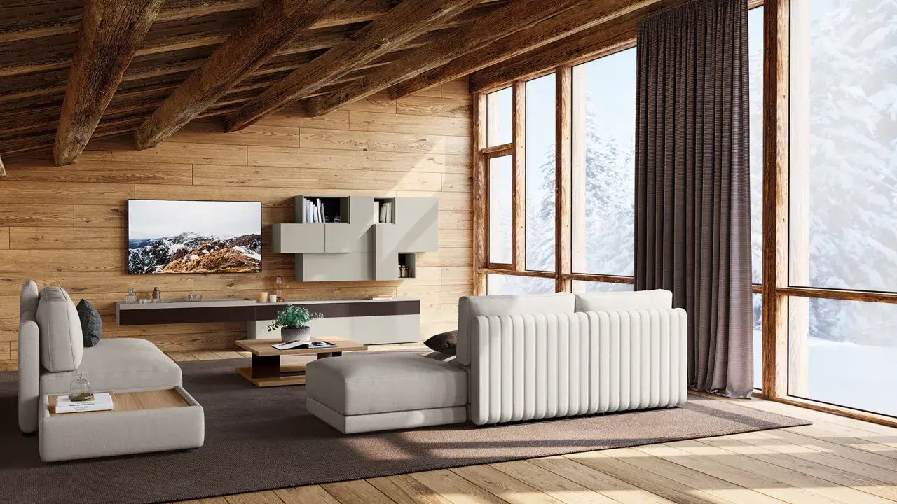 Accogliente soggiorno con travi in legno a vista, mobili chiari e vista innevata. I colori delle case di campagna si riflettono nell'arredo.