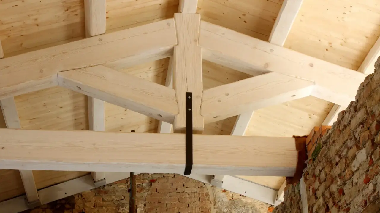 Struttura di una capriata in legno, con travi a vista e tavolato in abete. La robustezza della capriata in legno è evidente.