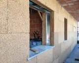 Blocchi di sughero per un eccellente isolante termico per pareti esterne. Costruzione in corso con aperture per finestre.