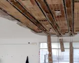 Solaio imbarcato con travi in laterizio a vista e armature metalliche. Caduta di calcinacci e pilastri in mattoni parzialmente distrutti.