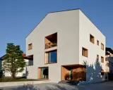 Casa moderna con ampie vetrate e balconi, un esempio di case in classe a vantaggi e svantaggi.