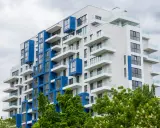 Moderno palazzo con balconi bianchi e blu, un esempio di edilizia popolare dal design accattivante.