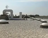 Tetto piano ricoperto di ghiaia, con lucernari a cupola e condotti di ventilazione. Il vespaio ghiaia protegge la copertura.