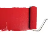 Rullo da pittura stende una striscia di vernice rosso antico, ideale per il colore esterno di una casa.