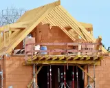Costruzione di una casa in mattoni con tetto in legno. La struttura è in fase avanzata, con un **durc di congruità** verificato per i lavori in corso.