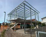 Struttura in acciaio per una casa in costruzione, con impalcati e tettoia visibili. Nessun difetto casa in acciaio evidente in questa fase.