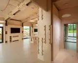 Interno di moderni edifici in legno con travi a vista, pareti in compensato e un'area living con TV.