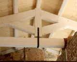 Struttura di una capriata in legno, con travi a vista e tavolato in abete. La robustezza della capriata in legno è evidente.