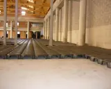 Struttura in costruzione con file di elementi prefabbricati che creano un vuoto sanitario. Colonne e pareti in mattoni visibili.