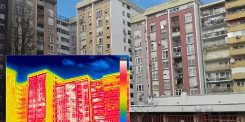 Termografia di palazzi residenziali che evidenzia la trasmittanza termica periodica, con aree rosse e gialle che indicano dispersioni di calore.