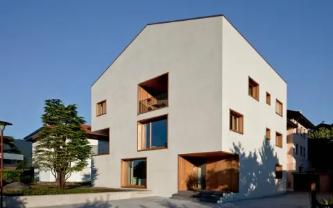 Casa moderna con ampie vetrate e balconi, un esempio di case in classe a vantaggi e svantaggi.