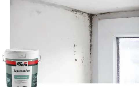 Angolo di una stanza con muffa sul muro e sul soffitto, accanto a un barattolo di vernice antimuffa San Marco Superconfort Anticondensa.