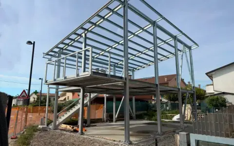 Struttura in acciaio per una casa in costruzione, con impalcati e tettoia visibili. Nessun difetto casa in acciaio evidente in questa fase.