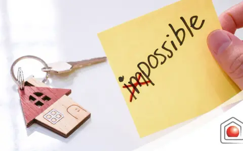 Chiavi di casa con portachiavi a forma di casetta. Post-it giallo con "impossible" barrato, simboleggia che l'edilizia convenzionata pro e contro può diventare possibile.