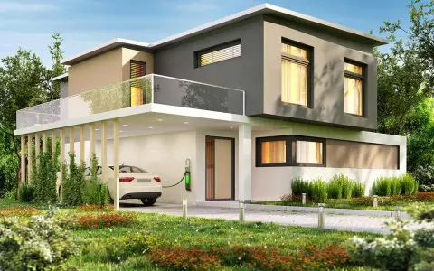 Casa moderna con tetto piano, balcone in vetro e un'auto bianca in carica. Il colore esterno casa verde si integra con il giardino lussureggiante.