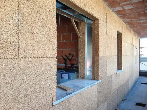 Blocchi di sughero per un eccellente isolante termico per pareti esterne. Costruzione in corso con aperture per finestre.