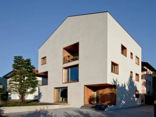 Casa moderna con ampie vetrate e balconi, un esempio di case in classe a vantaggi e svantaggi.