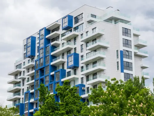 Moderno palazzo con balconi bianchi e blu, un esempio di edilizia popolare dal design accattivante.