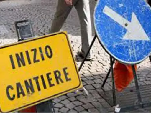Segnale giallo "Inizio cantiere" e segnale blu con freccia a destra indicano lavori in corso.