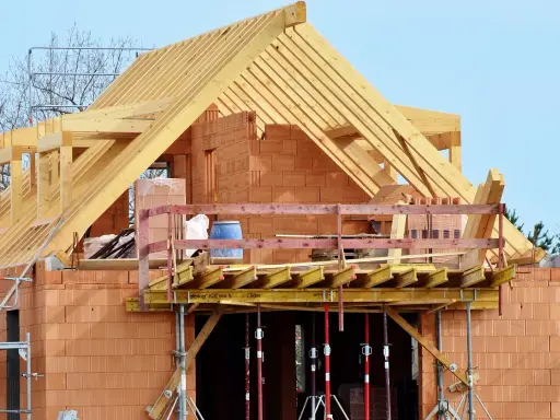 Costruzione di una casa in mattoni con tetto in legno. La struttura è in fase avanzata, con un **durc di congruità** verificato per i lavori in corso.