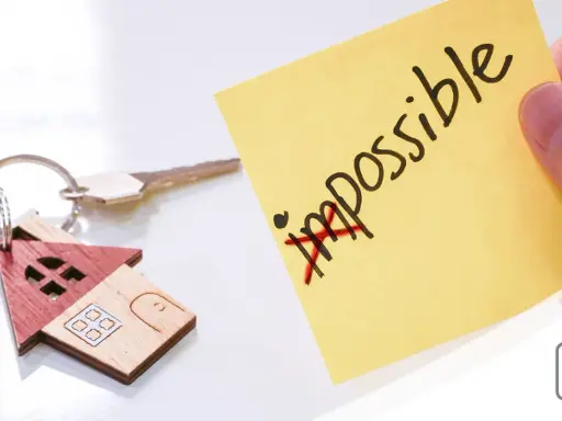 Chiavi di casa con portachiavi a forma di casetta. Post-it giallo con "impossible" barrato, simboleggia che l'edilizia convenzionata pro e contro può diventare possibile.