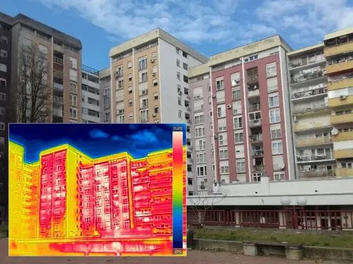 Termografia di palazzi residenziali che evidenzia la trasmittanza termica periodica, con aree rosse e gialle che indicano dispersioni di calore.