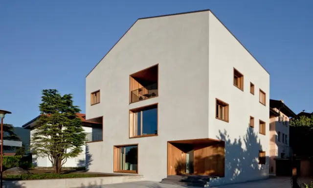 Casa moderna con ampie vetrate e balconi, un esempio di case in classe a vantaggi e svantaggi.