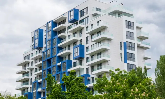 Moderno palazzo con balconi bianchi e blu, un esempio di edilizia popolare dal design accattivante.