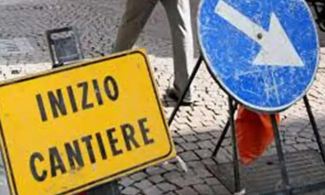 Segnale giallo "Inizio cantiere" e segnale blu con freccia a destra indicano lavori in corso.