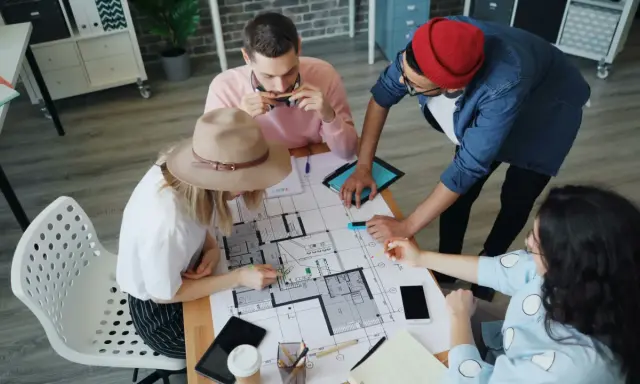 Team discute progetto edilizio, pianificando il pagamento stato avanzamento lavori privati.