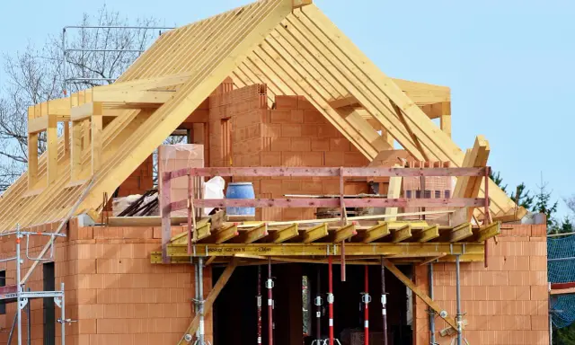 Costruzione di una casa in mattoni con tetto in legno. La struttura è in fase avanzata, con un **durc di congruità** verificato per i lavori in corso.