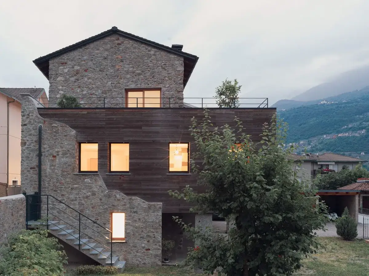 Rinnovata casa di campagna con pietra e legno, i colori naturali si fondono con il paesaggio montano.