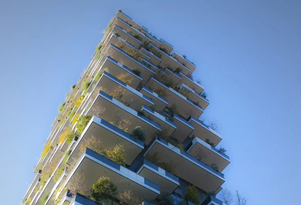 Grattacielo con balconi verdi, esempio di materiali da costruzione innovativi che integrano natura e architettura.