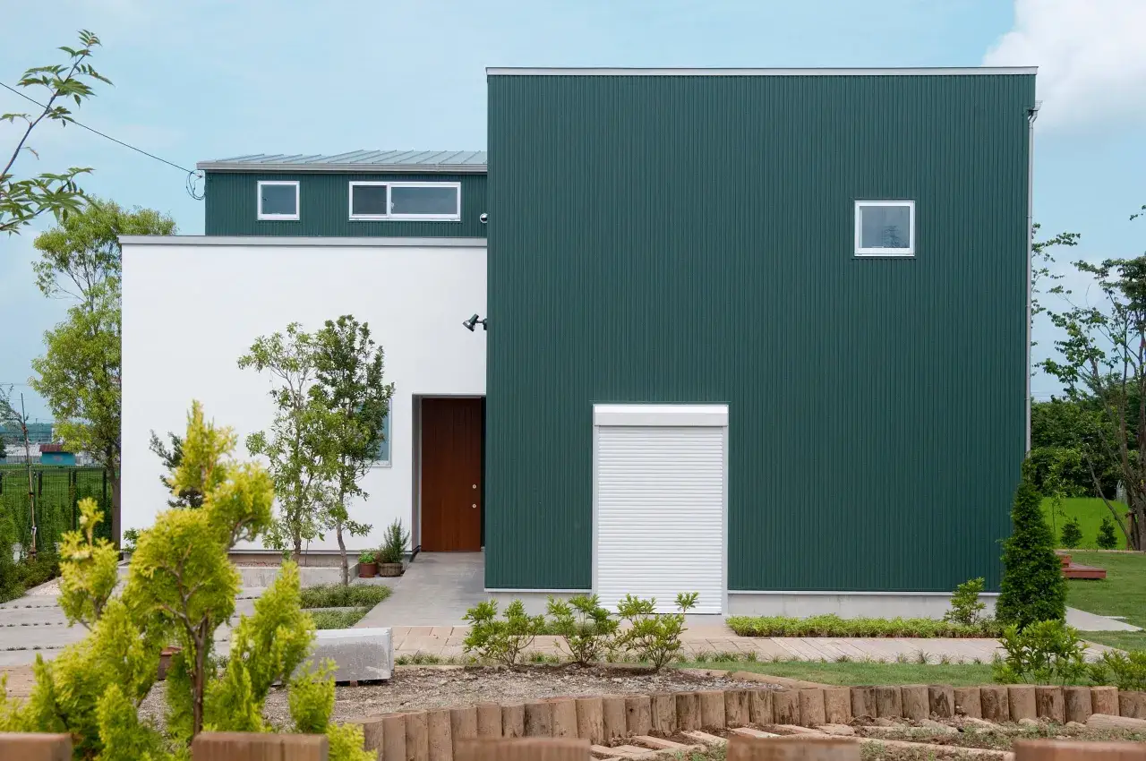 Casa moderna con un vivace colore esterno casa verde, contrastante con una parete bianca e una porta in legno.
