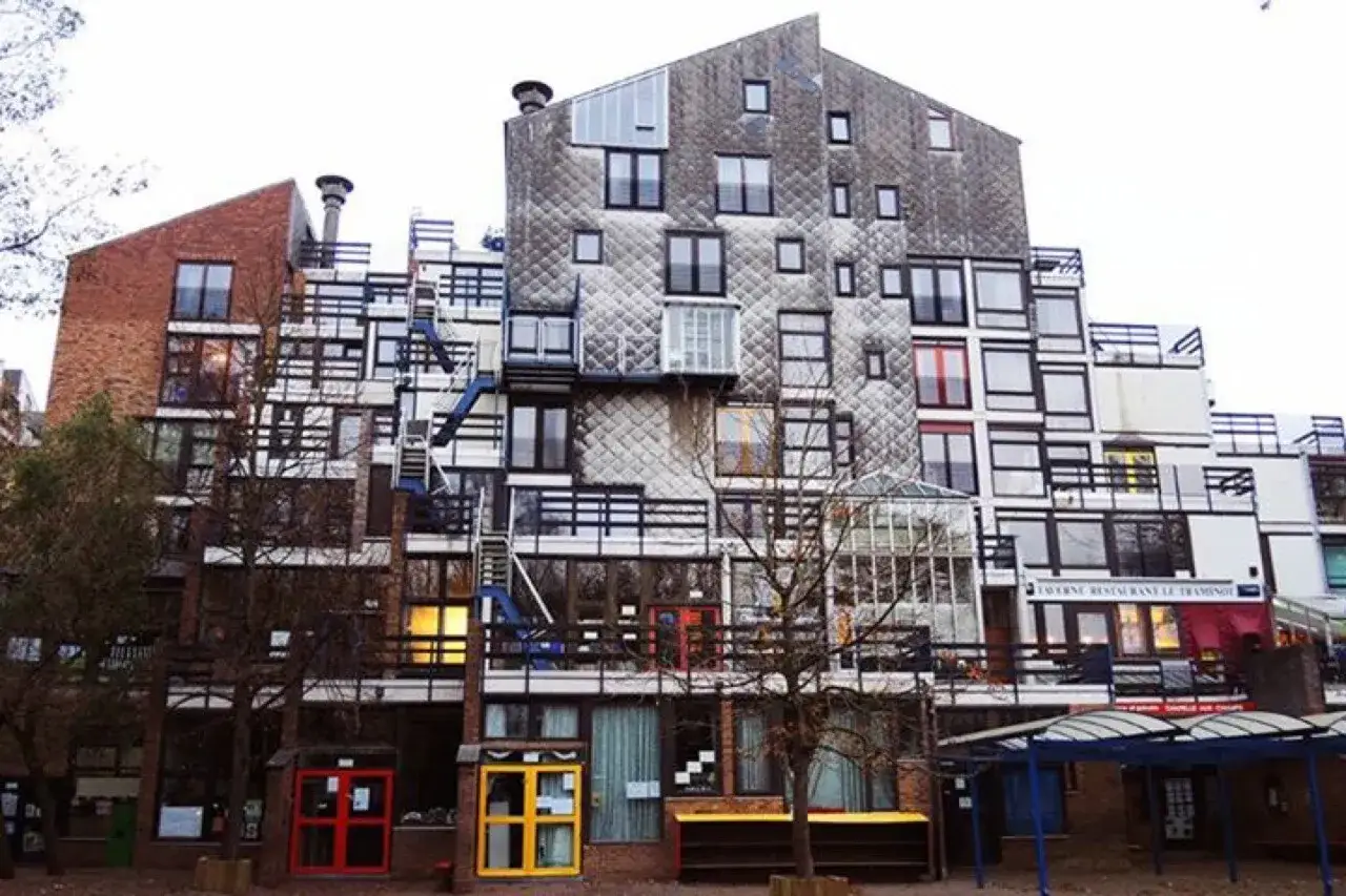 Edificio residenziale con facciata a mosaico, scale esterne e balconi, un esempio di architettura di Lucien Kroll.