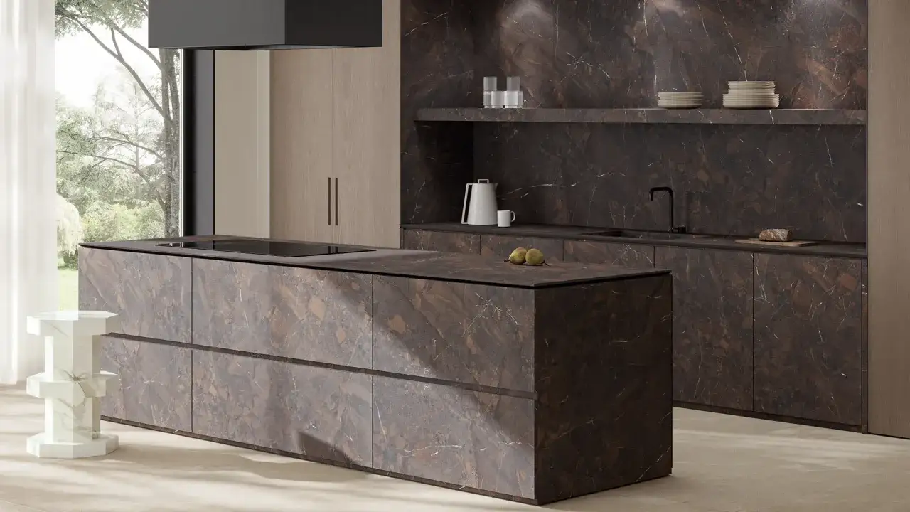 L'isola e le ante della cucina presentano un'elegante finitura in marmo scuro, un esempio di colori cucine moderne che unisce lusso e praticit&agrave;.